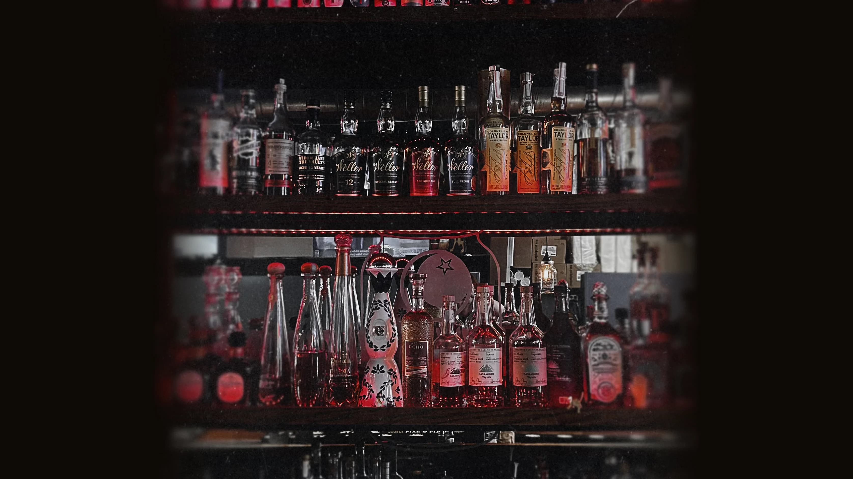 The backlit bourbon and whiskey shelves at The Mason Jar in Greer, SC